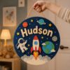 Picture of Personalized Space Name Sign, Custom Rocket Door Hanger, Astronaut Kids Room Decor, Outer Space Nursery Wall Art, Round Wood Baby Gift